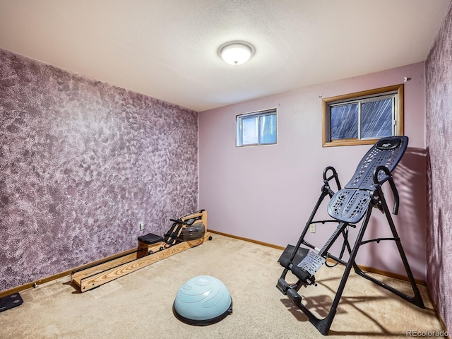 workout room featuring a textured ceiling and carpet