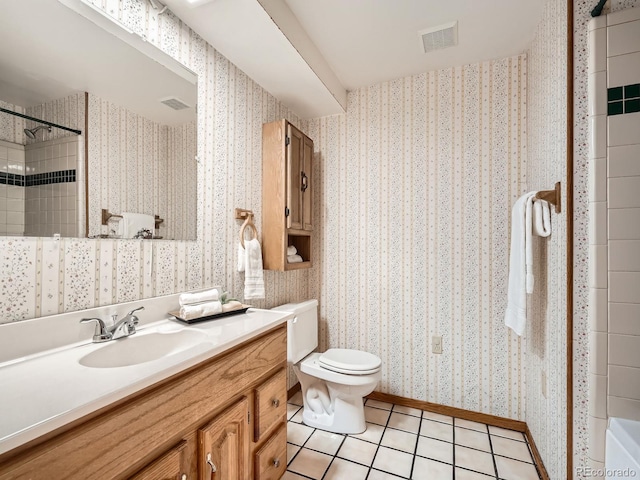 bathroom featuring toilet, tile patterned floors, tiled shower, and vanity