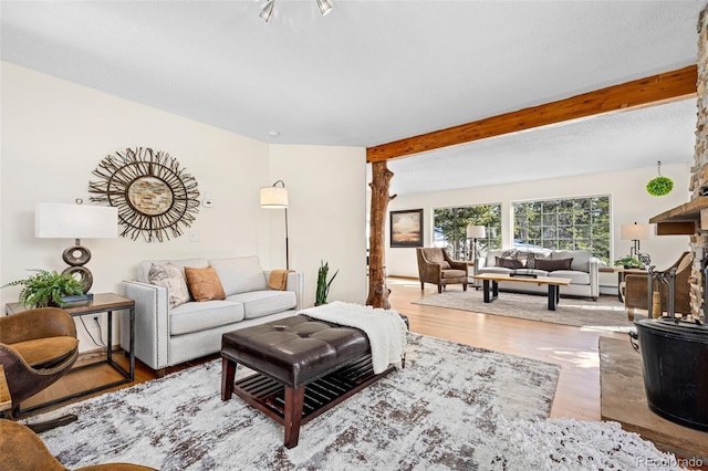 living room with beamed ceiling and wood finished floors