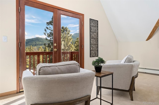 sitting room featuring a mountain view, a baseboard radiator, baseboards, light colored carpet, and vaulted ceiling