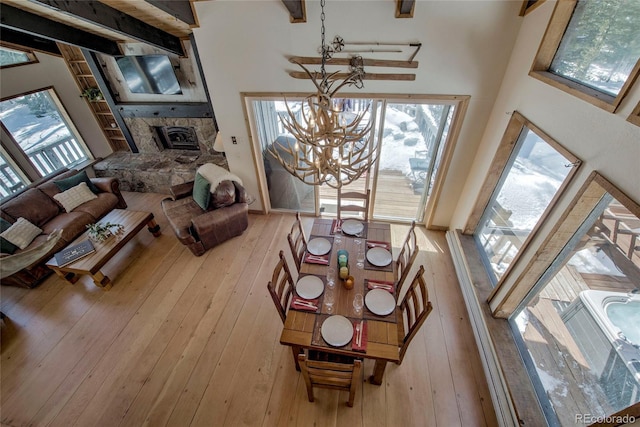 68 Starlit Ln, Blue River, CO 80424 - living room with beam ceiling, light wood-type flooring, a chandelier, and a fireplace