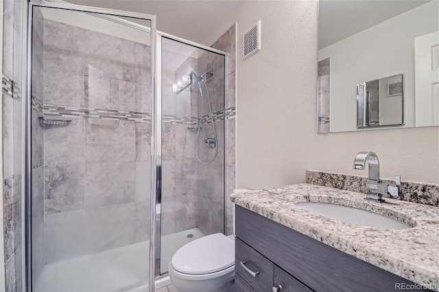 bathroom featuring vanity, toilet, and walk in shower