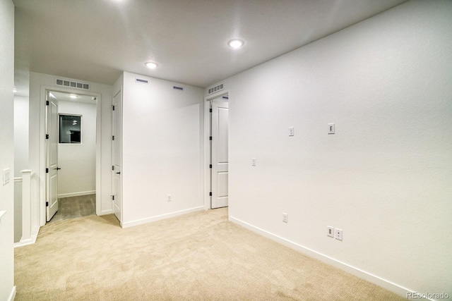 unfurnished room featuring recessed lighting, baseboards, visible vents, and light colored carpet