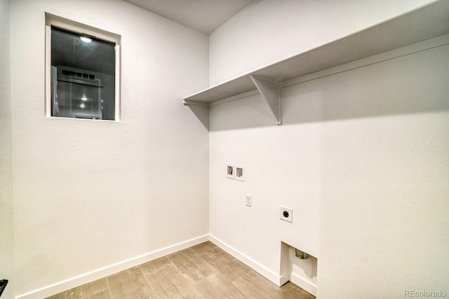 washroom with hookup for a washing machine, light wood-style floors, electric dryer hookup, laundry area, and baseboards