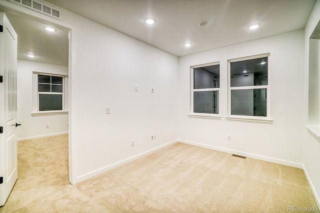 empty room featuring recessed lighting, light carpet, visible vents, and baseboards