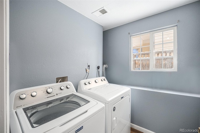 laundry area featuring a textured wall, laundry area, visible vents, and washer and dryer