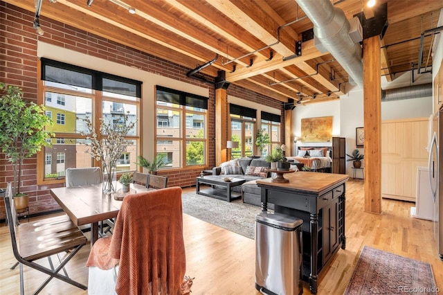 2955 Inca St Unit 2P, Denver, CO 80202 - living area with light wood finished floors, beam ceiling, and brick wall