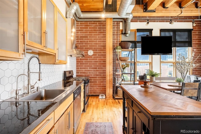 2955 Inca St Unit 2P, Denver, CO 80202 - kitchen featuring wooden counters, light wood finished floors, appliances with stainless steel finishes, brick wall, and tasteful backsplash