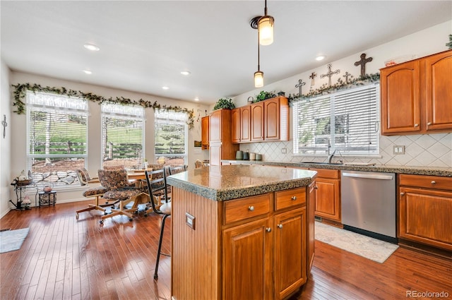 kitchen with a center island, backsplash, dishwasher, and hardwood / wood-style floors