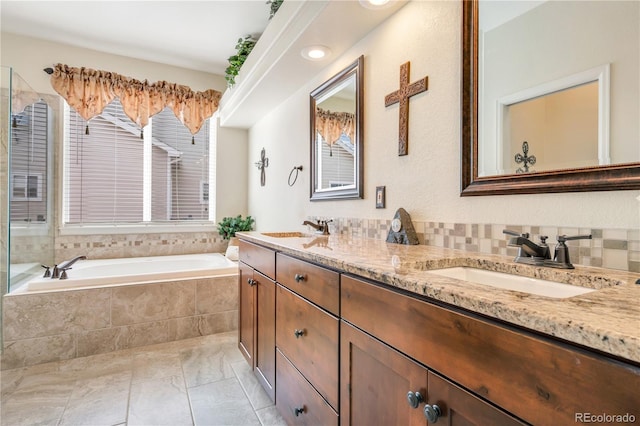 bathroom featuring backsplash, a relaxing tiled tub, vanity, and tile patterned floors