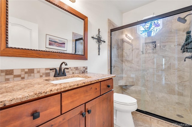 bathroom featuring decorative backsplash, tile patterned floors, vanity, toilet, and walk in shower