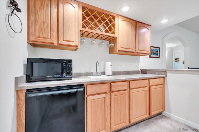 kitchen featuring sink, light brown cabinetry, and black appliances