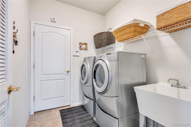 laundry area with sink, light tile patterned floors, and washing machine and clothes dryer