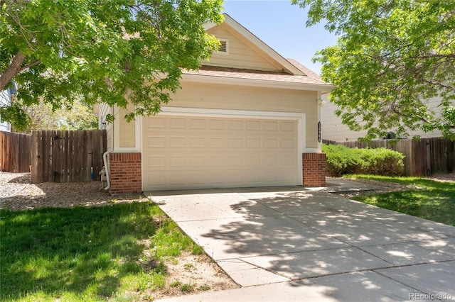 view of property hidden behind natural elements with brick siding, a garage, and fence