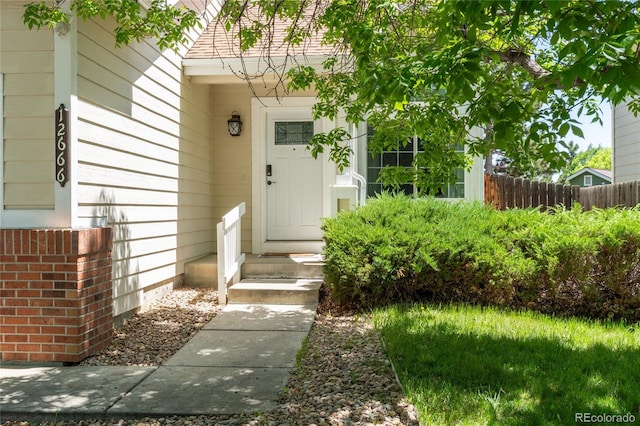 doorway to property featuring fence