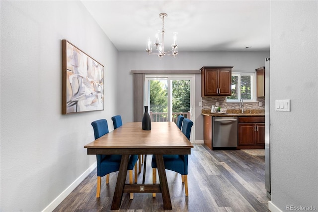 dining room featuring dark wood-style floors, a chandelier, and baseboards