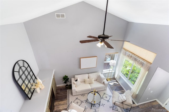 living room with baseboards, wood finished floors, ceiling fan, and high vaulted ceiling