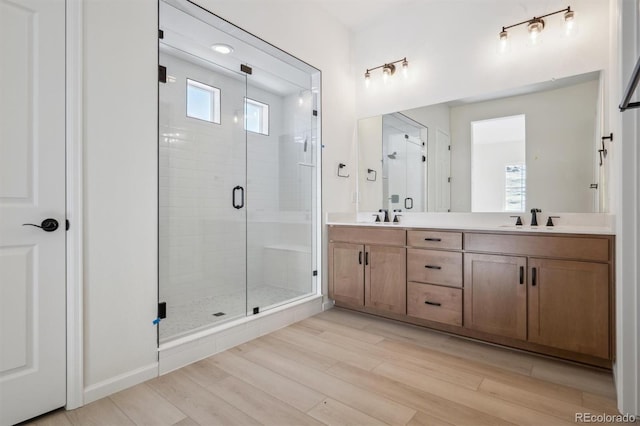 bathroom featuring plenty of natural light, vanity, wood-type flooring, and an enclosed shower