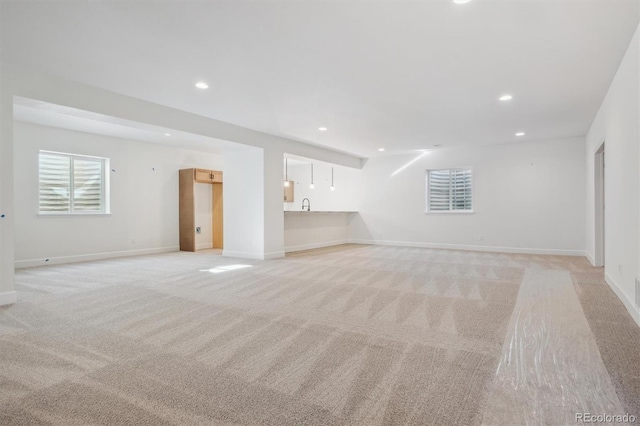 unfurnished living room featuring light carpet