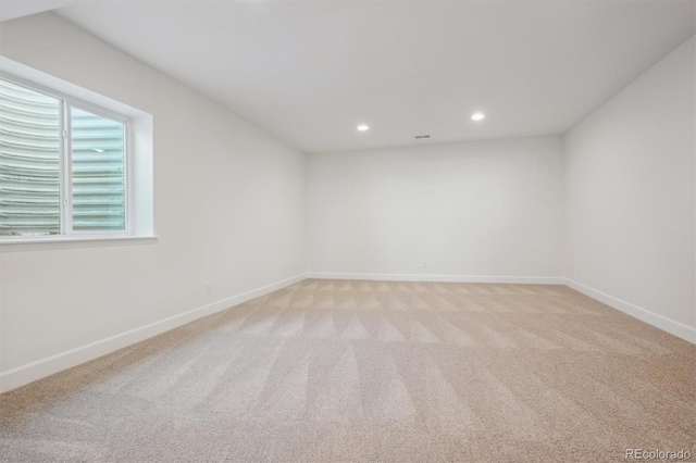 unfurnished room featuring light carpet