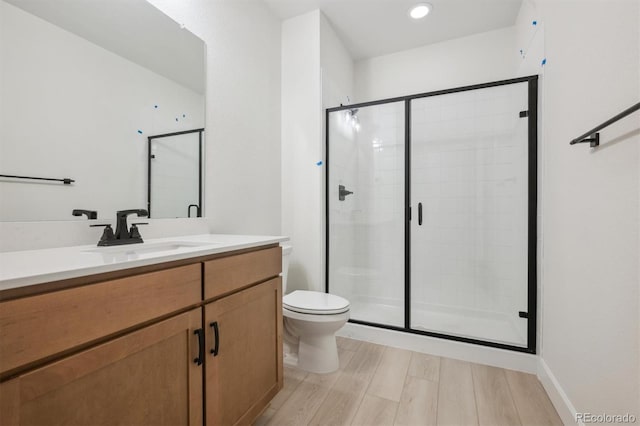 bathroom with vanity, an enclosed shower, and toilet