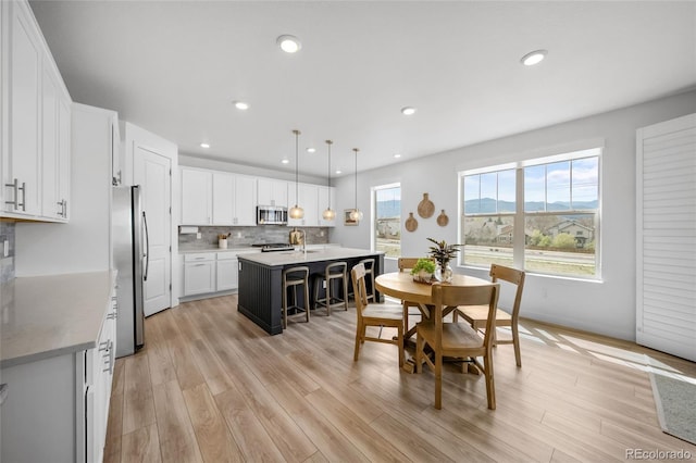 dining room with light wood-style flooring and recessed lighting