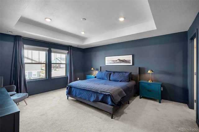 carpeted bedroom with a tray ceiling, baseboards, and recessed lighting
