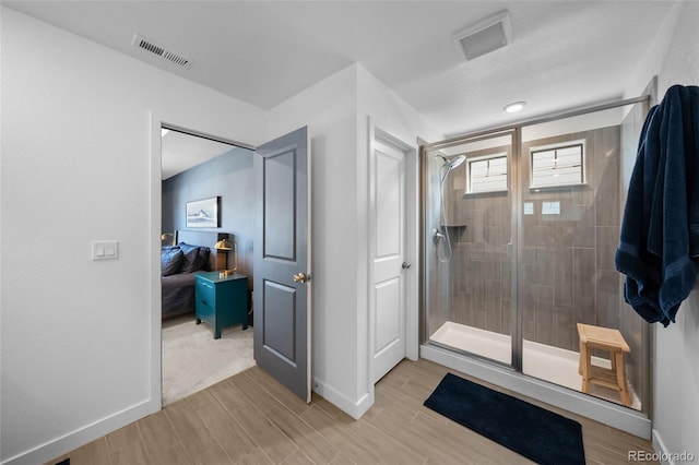 bathroom featuring wood tiled floor, visible vents, and a stall shower