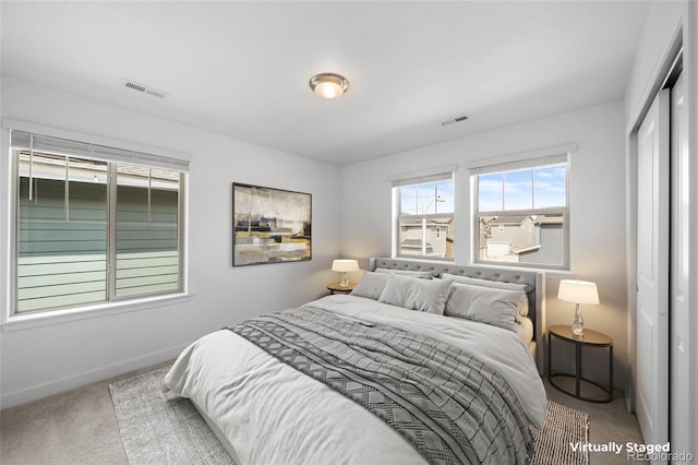 carpeted bedroom with baseboards, a closet, and visible vents