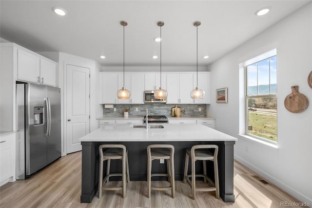 8109 Mount Ouray Rd, Littleton, CO 80125 - kitchen featuring stainless steel appliances, visible vents, a kitchen bar, backsplash, and light countertops