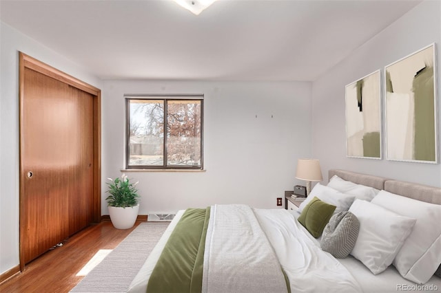 bedroom with a closet, baseboards, and wood finished floors