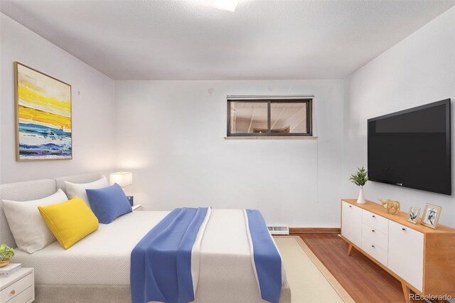 bedroom with wood finished floors and visible vents