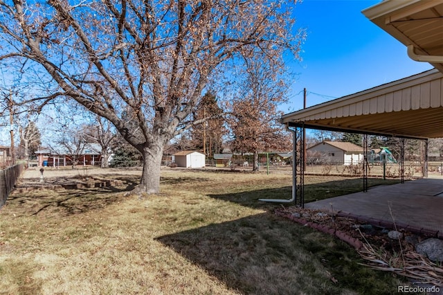 view of yard with a playground, an outdoor structure, a storage shed, and fence