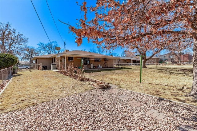 rear view of property with fence and a lawn