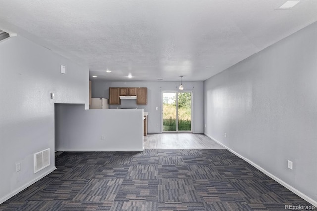 545 Tanager St, Brighton, CO 80601 - unfurnished living room featuring carpet floors and a textured ceiling