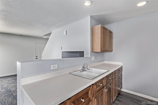 545 Tanager St, Brighton, CO 80601 - kitchen featuring light countertops, recessed lighting, a peninsula, a textured ceiling, and dark wood-type flooring