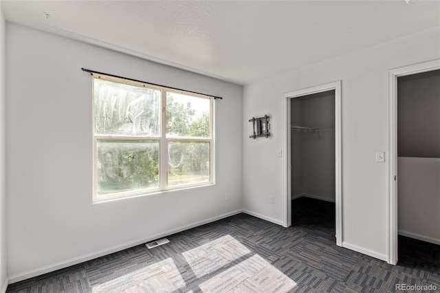 545 Tanager St, Brighton, CO 80601 - unfurnished bedroom with a walk in closet and baseboards