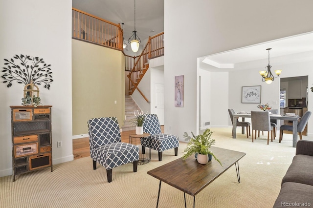 carpeted living room with a towering ceiling and an inviting chandelier