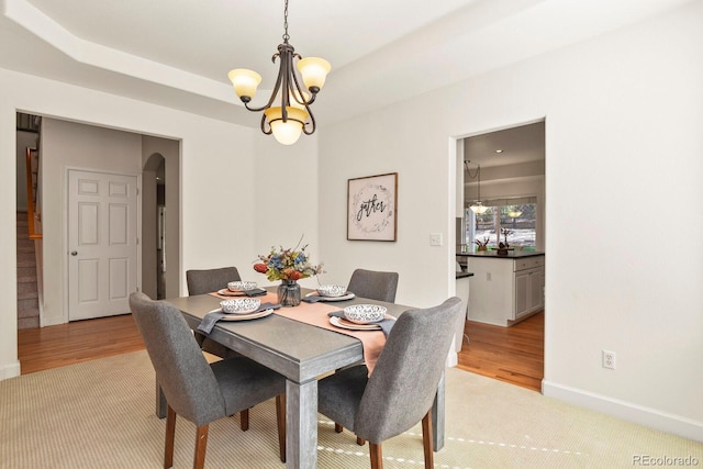 dining space with light hardwood / wood-style flooring and a chandelier