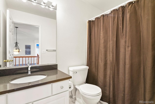 bathroom with toilet, walk in shower, and vanity