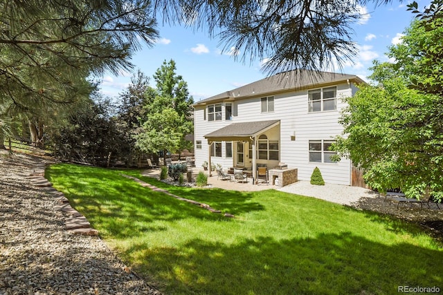 rear view of house with a yard and a patio area