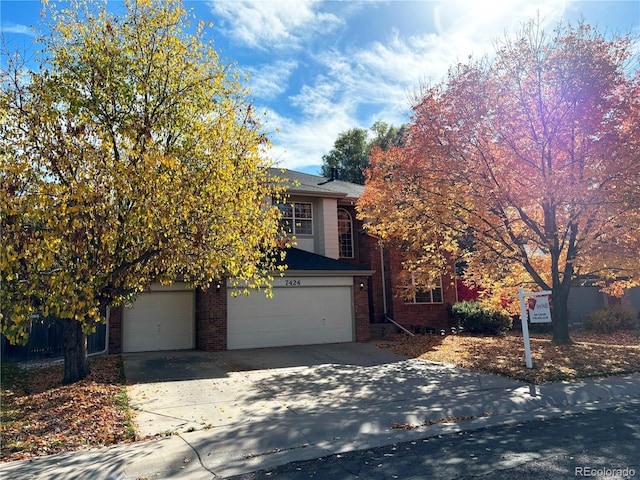 view of property hidden behind natural elements featuring a garage