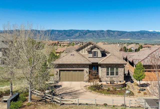 10731 Featherwalk Ln, Highlands Ranch, CO 80126 - view of front of home with a tiled roof, fence, stone siding, a garage, and driveway