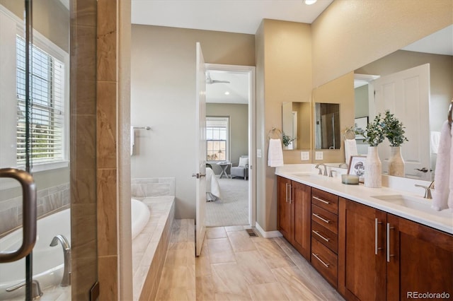 10731 Featherwalk Ln, Highlands Ranch, CO 80126 - full bathroom with double vanity, a garden tub, baseboards, and a sink
