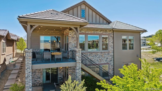 10731 Featherwalk Ln, Highlands Ranch, CO 80126 - rear view of house with stone siding, board and batten siding, and stairs