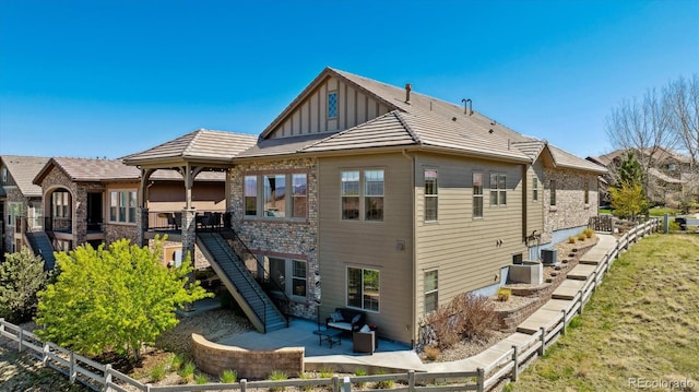 10731 Featherwalk Ln, Highlands Ranch, CO 80126 - back of property featuring board and batten siding, a patio area, fence, and central air condition unit