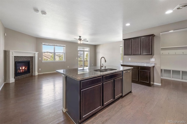 12210 Pine Post Dr, Parker, CO 80138 - kitchen with a sink, dishwasher, dark wood-style floors, dark brown cabinetry, and a brick fireplace