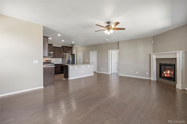 12210 Pine Post Dr, Parker, CO 80138 - unfurnished living room featuring a ceiling fan, baseboards, recessed lighting, a fireplace, and dark wood finished floors