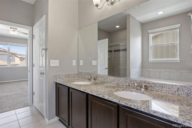 12210 Pine Post Dr, Parker, CO 80138 - bathroom featuring double vanity, a shower stall, tile patterned flooring, ceiling fan, and baseboards