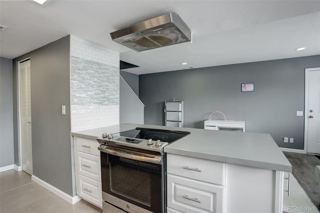 kitchen with visible vents, baseboards, white cabinets, light countertops, and stainless steel electric range oven